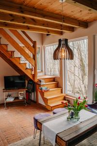 a living room with a staircase and a table at tuŻur domki nad potokiem in Osie