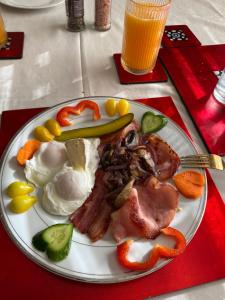 a plate of food with eggs meat and vegetables at Merrypetch in Safety Beach