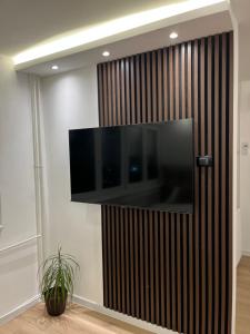 a television on a wall in a room at Refresh apartman in Belgrade