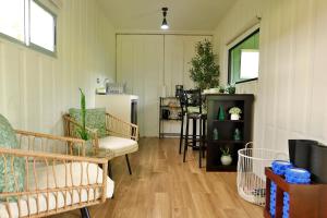 a living room with chairs and a kitchen with a refrigerator at Volcano Garden Suite with Hottub in Palma +22 photos