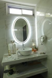 a white bathroom with a sink and a mirror at Volcano Garden Suite with Hottub in Palma