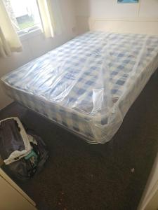 a bed is wrapped in plastic in a room at Towyn Happy Days K3 in Rowen +10 photos