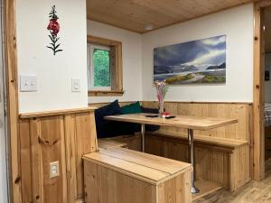 a room with wooden walls and a table in a room at Two Lakes Guesthouse in Seward