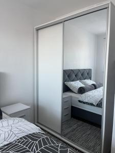 a mirror in a bedroom with a bed at ESEM stan na dan in Modriča