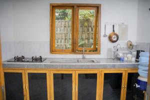 a kitchen counter with a sink and a window at Melaka Hill in Culik +55 photos