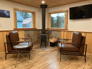 a living room with two chairs and a fireplace at Two Lakes Guesthouse in Seward