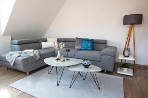 a living room with a couch and two tables at Ferienwohnungen Möhnesee - zentral, stilvoll und ruhig mit Balkon und Boxspringbetten in Möhnesee
