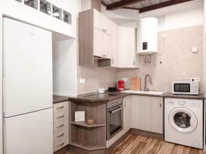 a kitchen with a white refrigerator and a dishwasher at La Casita de Ale Casa Rural cerca Puy du Fou in Polán