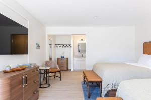 a bedroom with a bed and a desk with chairs at Salt Ranch Hotel in Nashville