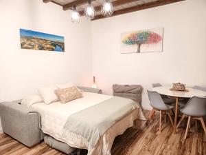 a bedroom with a bed and a table with chairs at La Casita de Ale Casa Rural cerca Puy du Fou in Polán