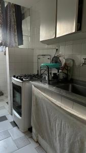 a kitchen with a sink and a stove at Quarto privativo confortável próximo a ufba, praia, comercio e zoológico in Salvador