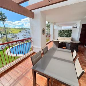 a dining room with a table and chairs on a balcony at Feel The Vibe Alcaidesa in La Alcaidesa