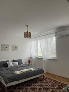 a white bedroom with a bed and a window at Relax Visoko Apartman in Visoko
