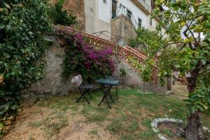 a table and chair in a yard next to a building with flowers at Casa de Santa Rita in Chaves