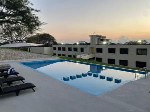 a swimming pool in front of a building at LOS BAMBUES HOTEL in La Tinaja