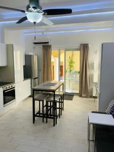 a kitchen with a table and chairs and a ceiling fan at Oceans Beach Condo in Morne Rouge