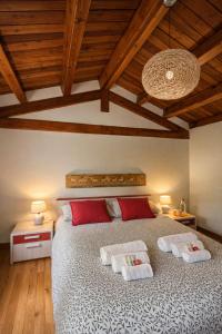 un dormitorio con una cama grande con almohadas rojas y blancas en B&B Villa Euganea, en Torreglia 21 fotos más