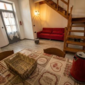 a living room with a red couch and a red rug at Casa Tziu Predu - Centro Nuoro - B&Brothers in Nuoro