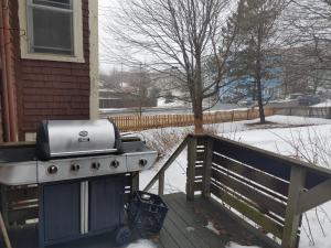 a grill sitting on a deck in the snow at Nigam's Sweet Home in Saint John
