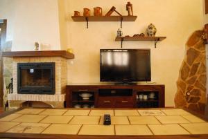 a living room with a television and a fireplace at Casa Rural Parajes del Júcar in Casas de Benítez +26 photos
