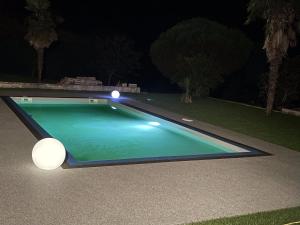 a swimming pool in a yard at night at Gîte, jacuzzi et piscine in Cintegabelle