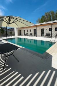 a swimming pool with a chair and an umbrella at Poiana Events - Vilă privată cu piscină aproape de Mamaia și Constanța in Poiana