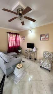 a living room with a couch and a ceiling fan at 1 Bed Apt overlooking Rodney Bay in Gros Islet