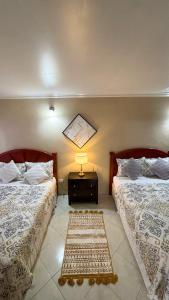 a bedroom with two beds and a rug on the floor at 1 Bed Apt overlooking Rodney Bay in Gros Islet