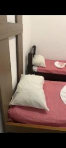 a bedroom with two beds with white pillows at Casa de Mainha in Salvador +5 photos