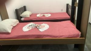 two twin beds with their mitts on them at Casa de Mainha in Salvador