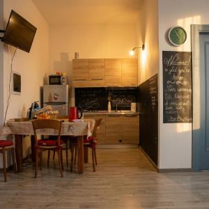 a kitchen with a dining table and a refrigerator at Casa Tziu Predu - Centro Nuoro - B&Brothers in Nuoro