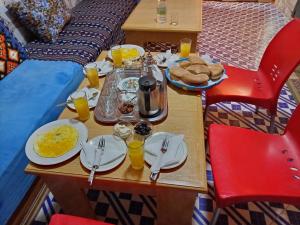 a table with breakfast foods and drinks on it at Maison d'hôtes de Zaida in Zeïda