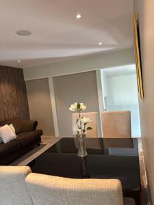 a living room with a vase with a flower on a table at 4-Bedroom Accommodation Near NTNU & Raufoss Business Area in Gjøvik