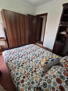 a bedroom with a bed with a comforter on it at Rest and relaxation in Madinaty