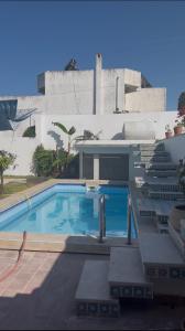 a swimming pool in front of a building at Villa Horizon & Pool Bizerte in Bizerte