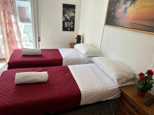 two beds in a room with red and white sheets at Venice Stefani Guesthouse in Marghera