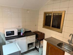 a small kitchen with a sink and a microwave at LKL appartements in Kinshasa