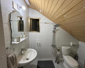 a white bathroom with a sink and a toilet at LKL appartements in Kinshasa +2 photos
