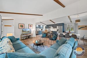 a living room with a blue couch and a kitchen at Pet-Friendly Lake Como Retreat 2BR in Lake Geneva