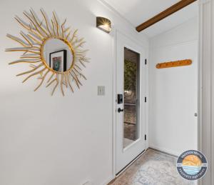 a sunburst mirror hanging on a wall next to a door at Pet-Friendly Lake Como Retreat 2BR in Lake Geneva