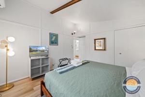 a bedroom with a bed and a flat screen tv at Pet-Friendly Lake Como Retreat 2BR in Lake Geneva +15 photos