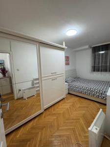 a room with a bed and a sliding glass door at Apartman 7 Foča in Foča