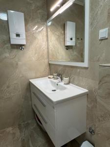 a bathroom with a white sink and a mirror at Apartman 7 Foča in Foča