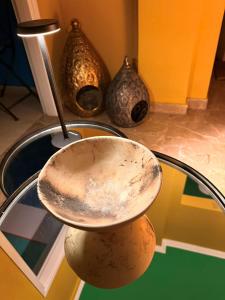 a bowl sitting on top of a table with vases at SuiteArtate in Patra