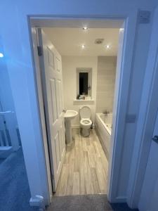 a bathroom with a toilet and a tub and a sink at Blackburn House for Professionals in Blackburn