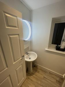 a white bathroom with a sink and a mirror at Blackburn House for Professionals in Blackburn +4 photos