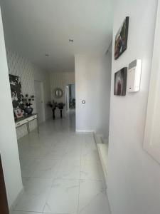 a hallway with white walls and a white tile floor at Chalet con 3 habitaciones Luz De Doñana in Mazagón