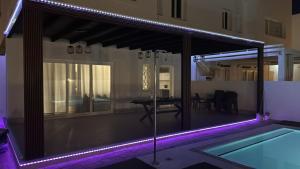 a house with a swimming pool with purple lights at Chalet con 3 habitaciones Luz De Doñana in Mazagón