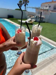 two people holding up two glasses of milkshakes at Chalet con 3 habitaciones Luz De Doñana in Mazagón
