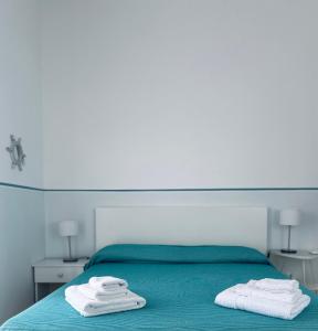 a bedroom with a bed with towels on it at Blu Bolivar in Marina di Camerota